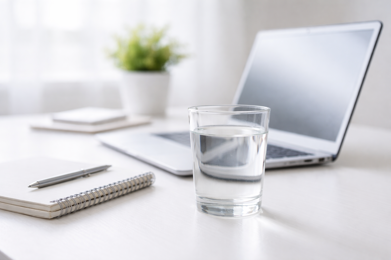 glas vatten vid laptop för fokus och mental energi